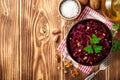 Beetroot salad with wallnuts and garlic in bowl on wooden table