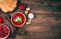 Beetroot soup with sour cream and basil among garlic, spices and bread on a wooden background Royalty Free Stock Photo