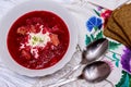 Beetroot soup, spoon, napkin on wooden background
