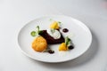 Beetroot terrine, goat cheese croquettes, horseradish sauce and dill cream on white dish Royalty Free Stock Photo