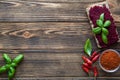 Colorful beetroot hummus with basil leaves and paprika spice on brown table background. Space for text Royalty Free Stock Photo