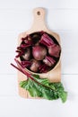 Beets with green tops in round metal pan on white wooden background, fresh red beetroot on backdrop kitchen table top view Royalty Free Stock Photo