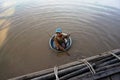 Beggar child floats in a basin of dirty Tonle SAP