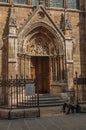 Beggar in front of gothic church on an alley at sunset in Paris.