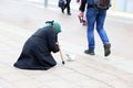 Beggar old woman asks for alms sitting on a city street Royalty Free Stock Photo