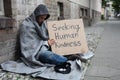 Beggar Showing Seeking Human Kindness Sign On Cardboard