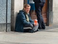 A beggar sits beneath a cash point in O`Connell Street in Dublin Ireland looking for a Euro or two to see him through the day Royalty Free Stock Photo