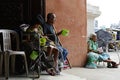 Beggar on wheelchair beside blind man using cellphone at church door gate portal