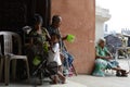 Beggar on wheelchair beside blind man using cellphone at church door gate portal