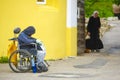 beggar in a wheelchair near the walls of a monastery in Borovsk, Russia