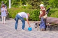 A beggarly elderly woman asks for alms on the embankment near a sculpture to Red Army soldier Sukhov Royalty Free Stock Photo