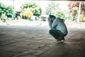 The beggars sat under the bridge with both hands holding to the head