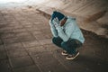 The beggars sat under the bridge with both hands holding to the head