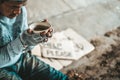 Beggars sitting under a bridge with cups have money