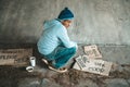 Beggars sitting under a bridge with cups have money