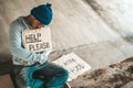Beggars sitting under the bridge with a sign, help please Royalty Free Stock Photo