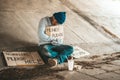 Beggars sitting under the bridge with a sign, please money