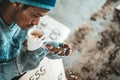 Begging under the bridge with a cup containing coins and instant noodles Royalty Free Stock Photo