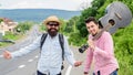 Begin adventure. Travelers with backpack and guitar ready to strat new journey. Men at edge of road hitchhiking. Friends Royalty Free Stock Photo