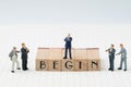Begin, company establish or start own business concept, miniature figure businessman standing on wooden stamp building the word B