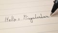 Beginner Burmese language learner writing Hello word Mingalarbar for homework on a notebook