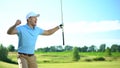 Beginner golf player with club in hand rejoicing successful shot, luck and sport Royalty Free Stock Photo