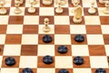 Beginning of chess - checkers game on wood board Royalty Free Stock Photo