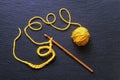 Beginning of crocheting from yellow wool. Dark background, copy space Royalty Free Stock Photo