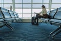 Beginning of his journey. Beautiful young woman looking out window while waiting to board aircraft in airport lounge Royalty Free Stock Photo