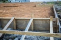 The beginning of a new construction build in a neighborhood with the foundation poured, dirt added and the wood based