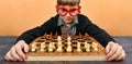 The beginning of a new game of chess with a young smart chess player in red glasses Royalty Free Stock Photo