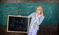 Beginning of new school season. Teacher welcomes school year. Woman teacher holds blackboard inscription back to school Royalty Free Stock Photo