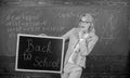 Beginning of new school season. Teacher welcomes school year. Woman teacher holds blackboard inscription back to school Royalty Free Stock Photo