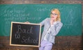 Beginning of new school season. Teacher welcomes school year. Woman teacher holds blackboard inscription back to school Royalty Free Stock Photo