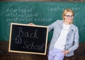 Beginning of new school season. Woman teacher formal suit holds blackboard inscription back to school. Lady educator in Royalty Free Stock Photo