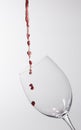 The beginning of red wine being poured into a glass on a gray background Royalty Free Stock Photo