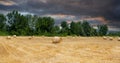 The beginning of a thunderstorm over a field of harvested wheat in bright colors Royalty Free Stock Photo