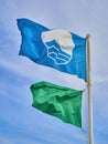 The FEEÃÂ´s Blue Flag beach and a green lifeguard flag over a blue sky background