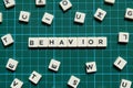 Behavior word made of square letter word on green square mat background. Royalty Free Stock Photo