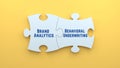 Behavioral Underwriting and Brand Analytics text message on jigsaw puzzle pieces. white puzzle and yellow background Royalty Free Stock Photo