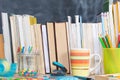 From behind the books you can see a school board. A lot of school aids are arranged on the desk Royalty Free Stock Photo