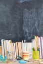 From behind the books you can see a school board. A lot of school aids are arranged on the desk Royalty Free Stock Photo