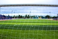 Behind goalie`s goal net. football and soccer field grass stadium Royalty Free Stock Photo