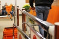 behind a man in blue jeans, walking with a shopping cart down the aisle of the cash register, having paid for the purchases, the Royalty Free Stock Photo