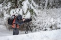 Behind the scene. Cameraman with video camera on tripod, shooting the film scene at outdoor location, on nature, forest