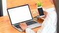 Behind shot of creative woman in stripped white shirt typing on white blank screen laptop.