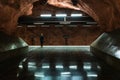 Behind shot of a girl in a hat waiting for a metro in a metro station