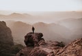 Behind shot of a man with a backpack standing on top of a cliff and enjoying the view Royalty Free Stock Photo