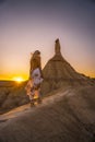 Behind shot of a young blonde girl in a beautiful dress in a desert in Las Bardenas Reales, Spain