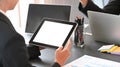 Behind shot of young businessman holding a white blank screen computer tablet while discussing about new business project. Royalty Free Stock Photo